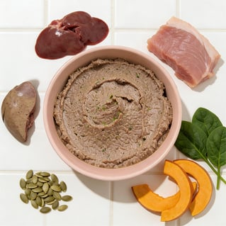 Bowl of Wundercat Duck with Tuna Pâté surrounded by fresh ingredients including duck, tuna, duck liver, pumpkin, spinach, and pumpkin seeds on a white tiled surface.